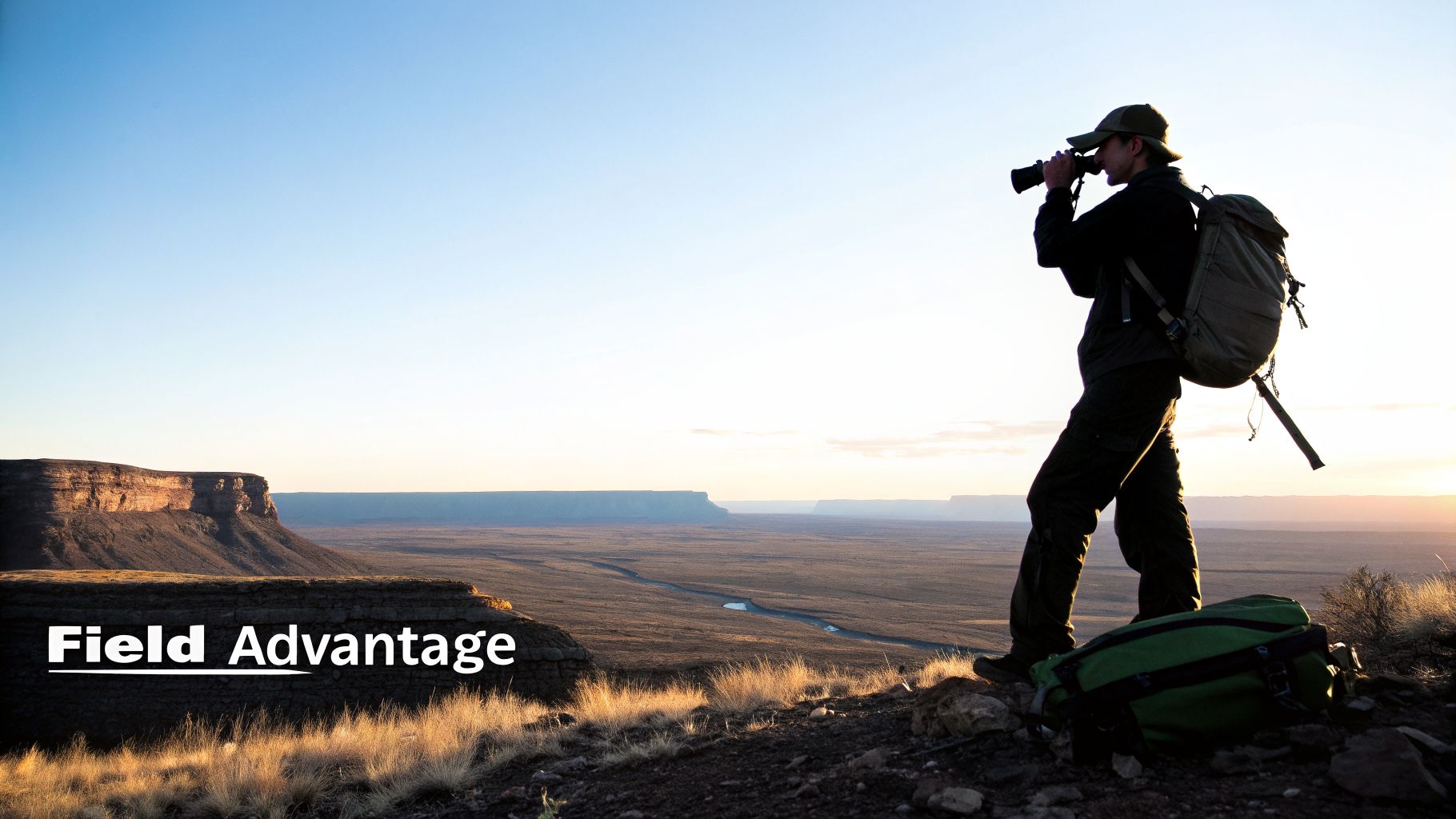 A person wearing a hat and backpack uses binoculars to observe a vast desert landscape at sunset, with the text 'Field Advantage'.